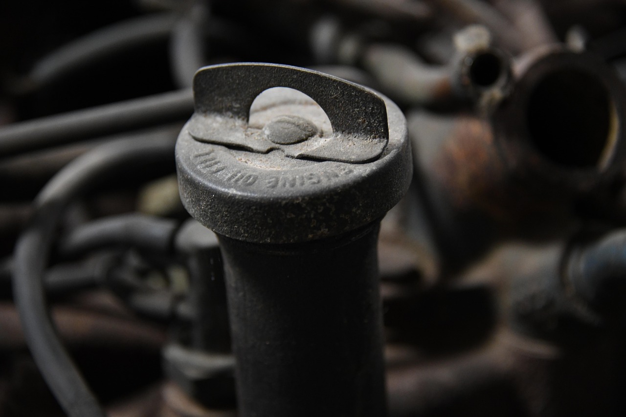 Mechaniker prüft angebissenes Kabel im Motorraum nach Marderbiss