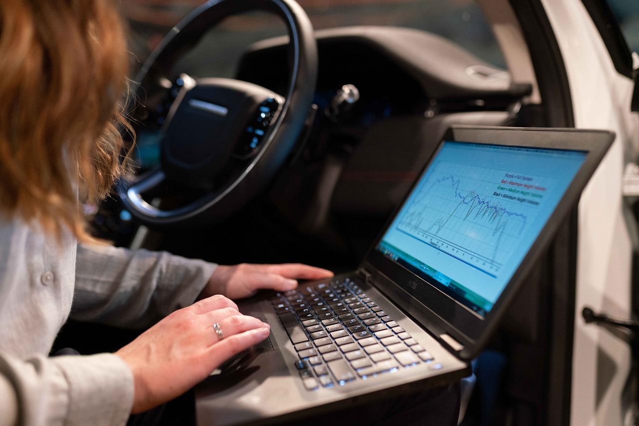 Person vergleicht Schadenmanagement Software auf Laptop und Tablet im Büro